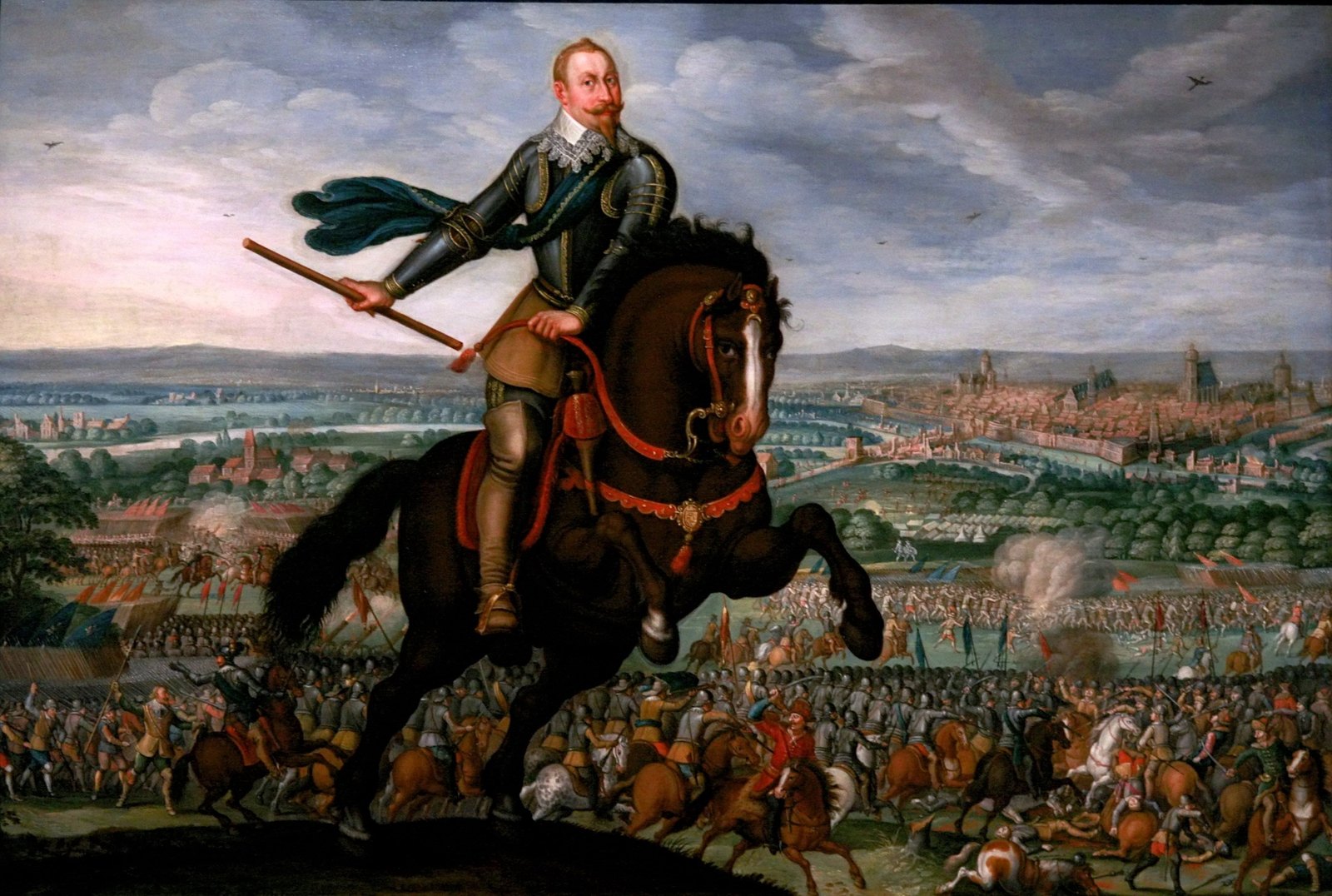 Seventeenth-century painting of Gustavus Adolphus in armor on a rearing dark horse, holding a baton, above a wide battlefield crowded with cavalry and infantry, gunsmoke on the right and the towers of Leipzig on the horizon.