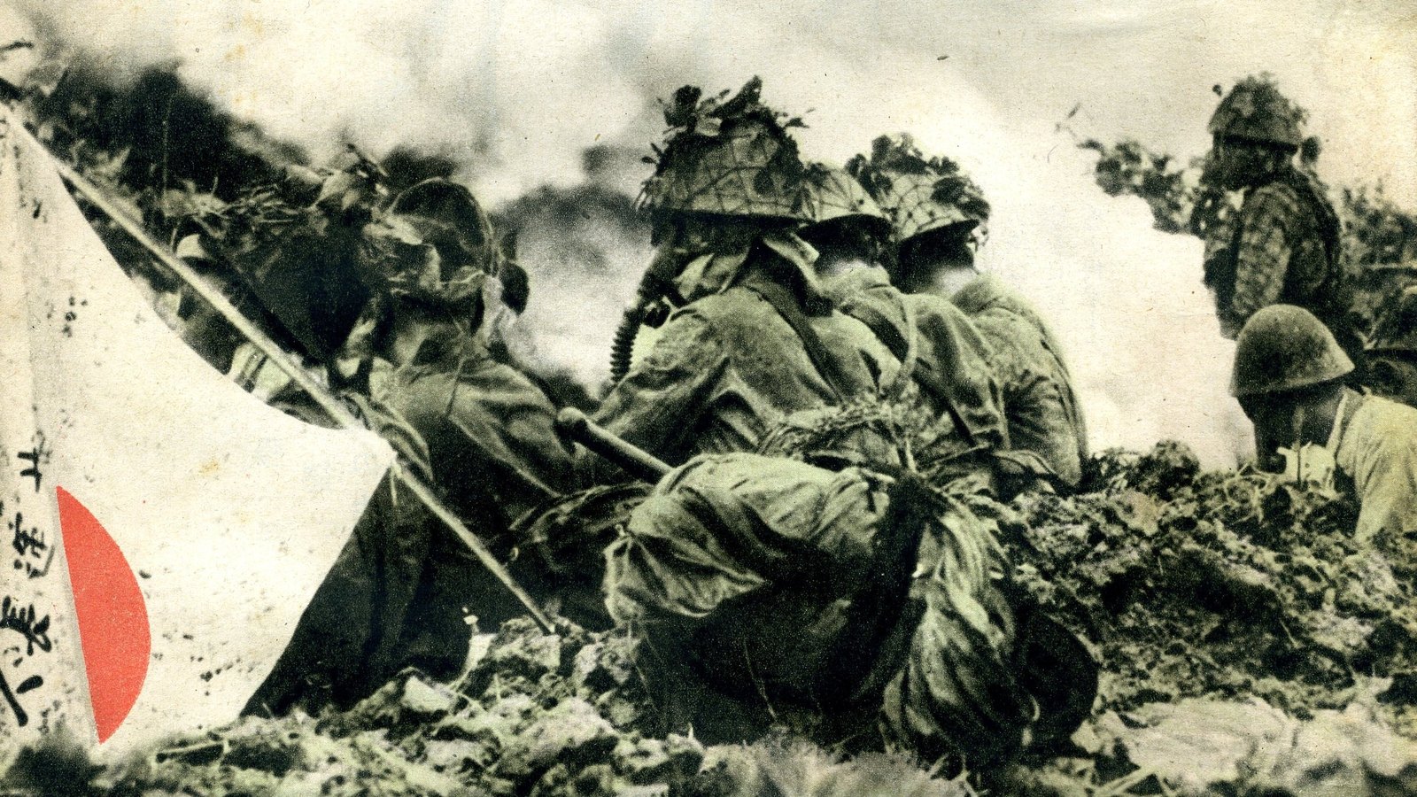 Old magazine photograph of Japanese soldiers in camouflaged helmets crouching behind a mound of earth in thick white smoke, with a Japanese flag with writing on it at the left.