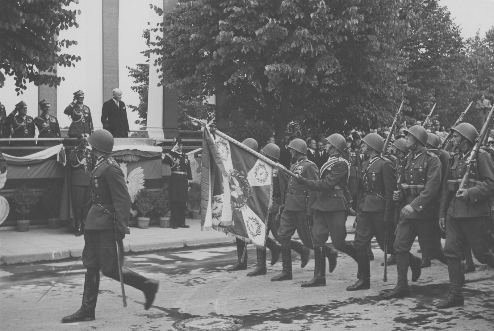 Piechota 1. Dywizji Piechoty Legionów w hełmach maszeruje ze sztandarem pułkowym w Wilnie, sierpień 1939
