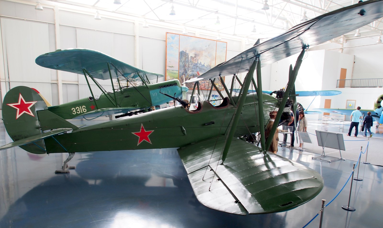 A restored Polikarpov Po-2 biplane in green paint with red stars, the aircraft type flown by the 588th Night Bomber Regiment, on display in the Central Air Force Museum at Monino near Moscow, with a second biplane behind it.
