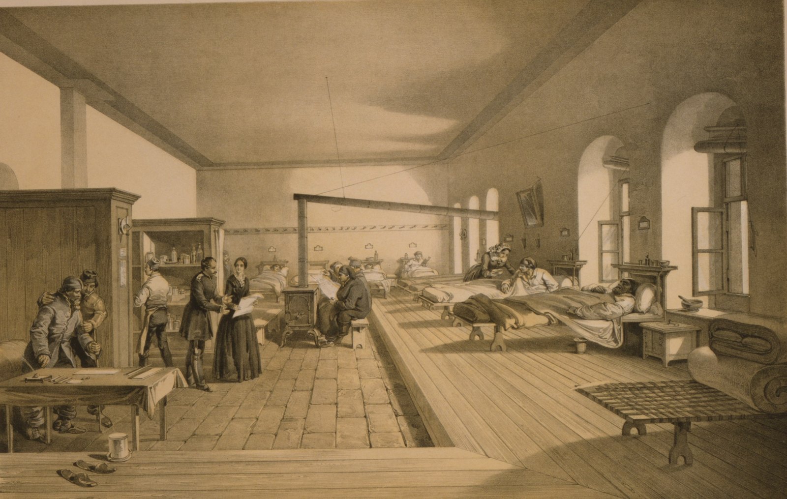 Tinted lithograph of a long hospital ward at Scutari: patients lie in beds along a raised wooden floor under arched windows, while a woman in a dark dress talks with an officer by a stove. One of the wards of the hospital at Scutari, drawn by William Simpson and lithographed by Edmund Walker for Day and Son, 1856. Public domain.
