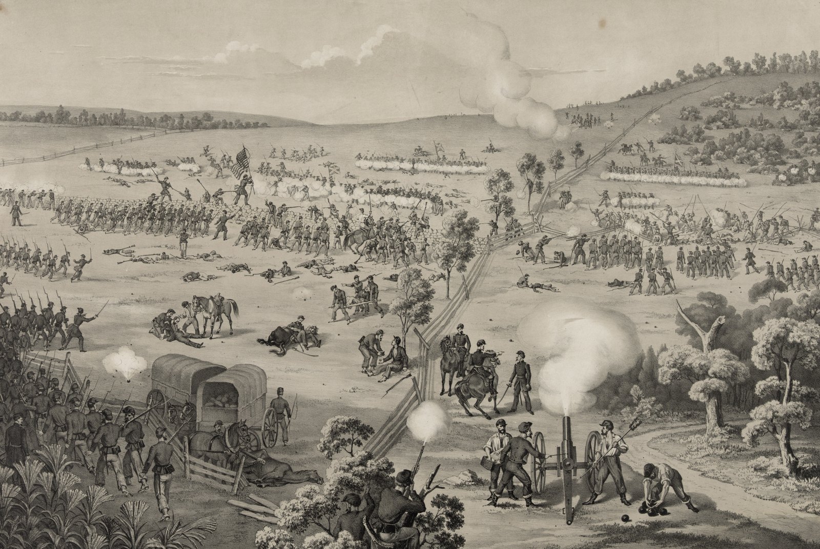 Black and white lithograph of a Civil War battle on rolling, wooded hillsides: lines of Union infantry with a flag charge across open fields strewn with fallen men and horses, a cannon fires from a road in the foreground, and smoke rises from a ridge in the distance.