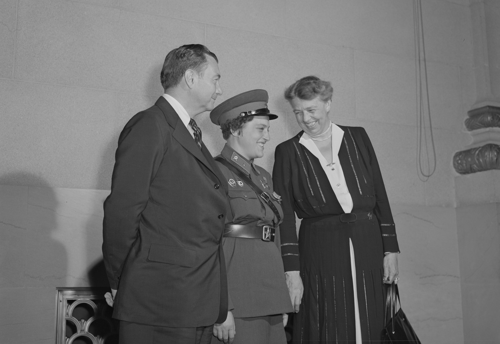 Lyudmila Pavlichenko in Soviet army uniform and peaked cap smiles between Justice Robert Jackson and Eleanor Roosevelt in Washington in September 1942