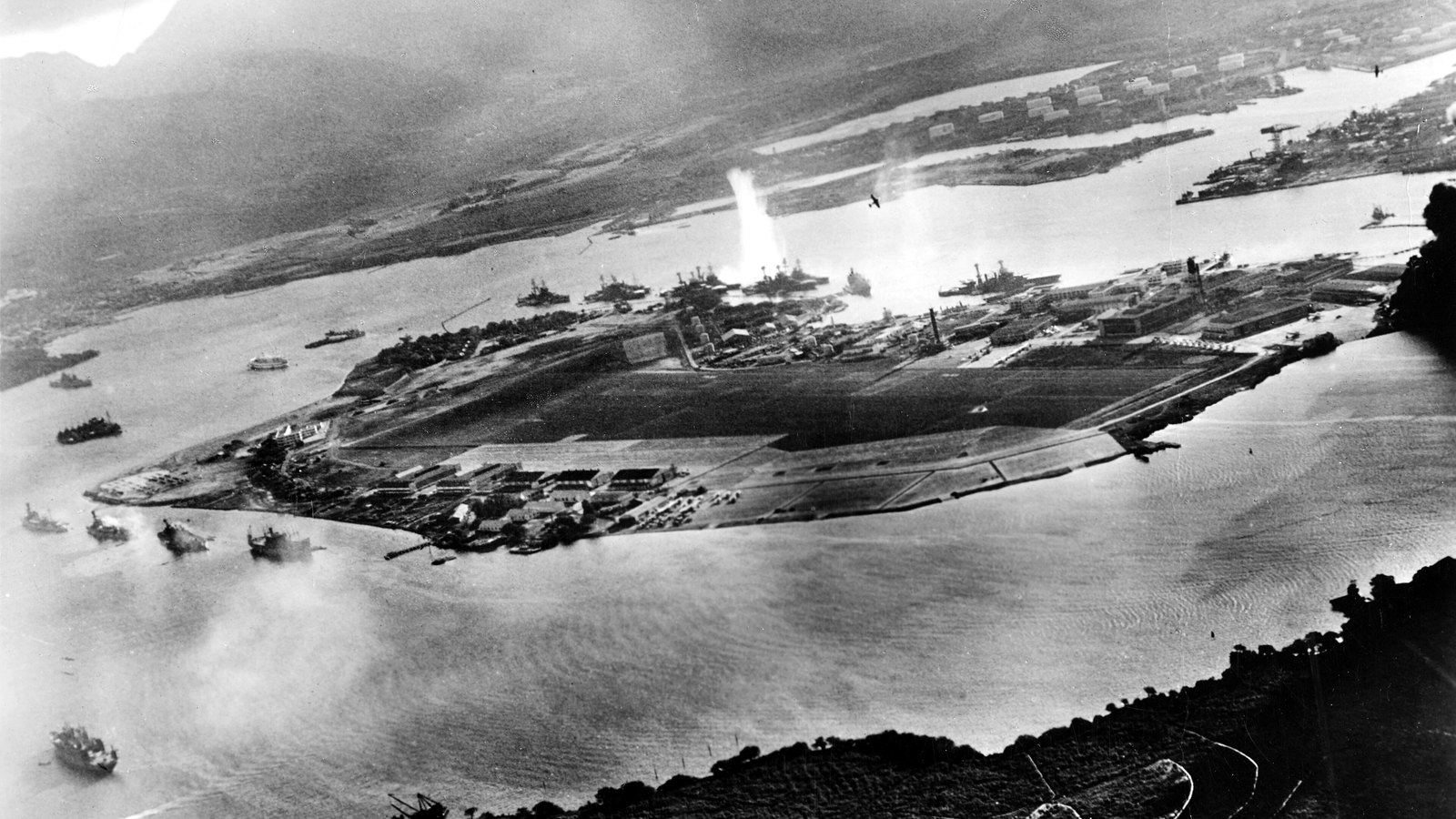 Smoke rising over the US battleships moored at Pearl Harbor on 7 December 1941
