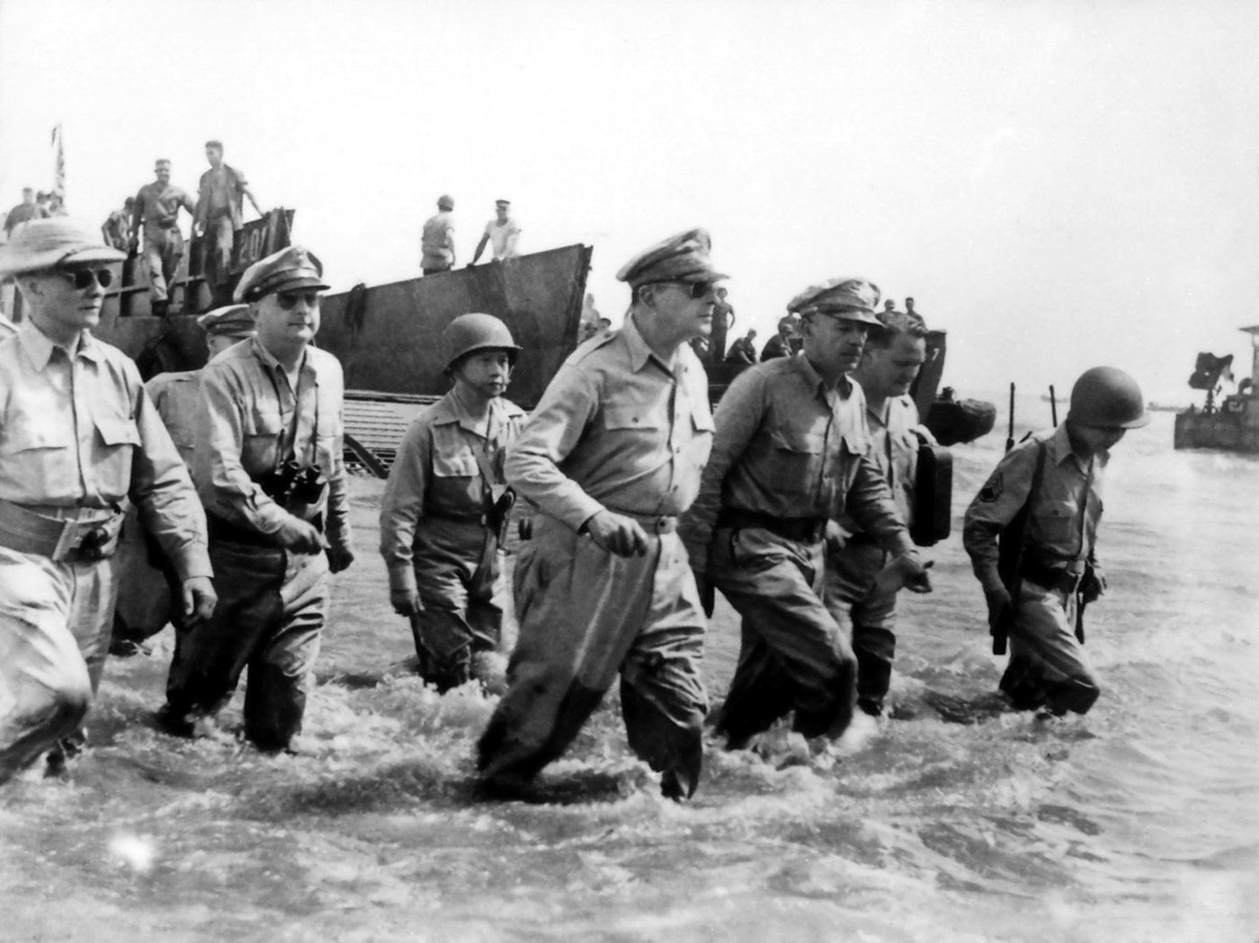 Photograph of General MacArthur and his officers wading through the surf from a landing craft