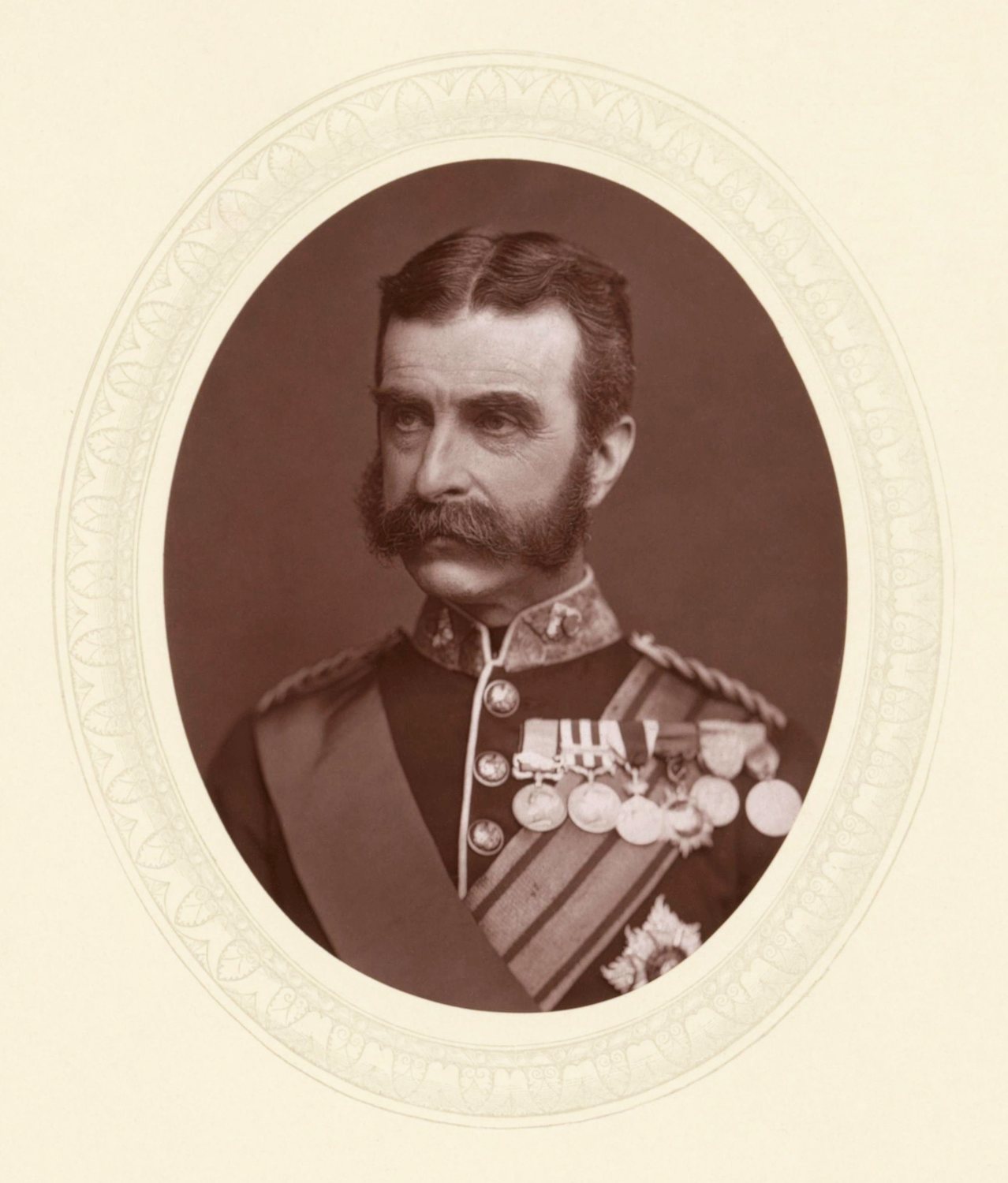 Oval photographic portrait of a moustached British general in dress uniform with medals