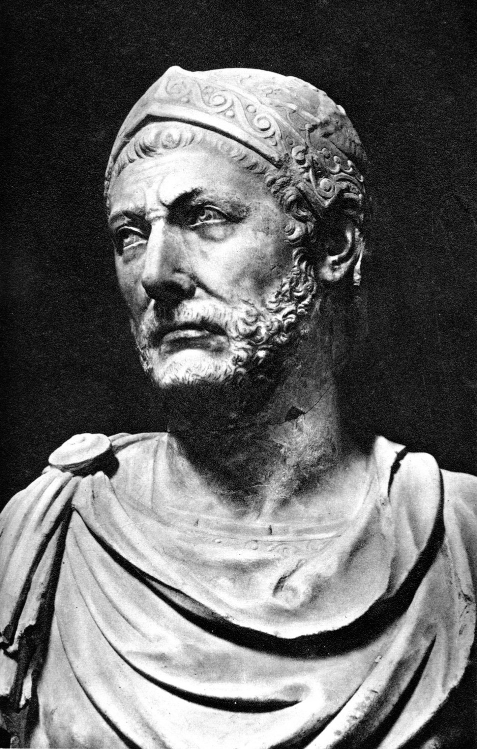 Black and white photograph of a marble bust of a bearded man in a helmet
