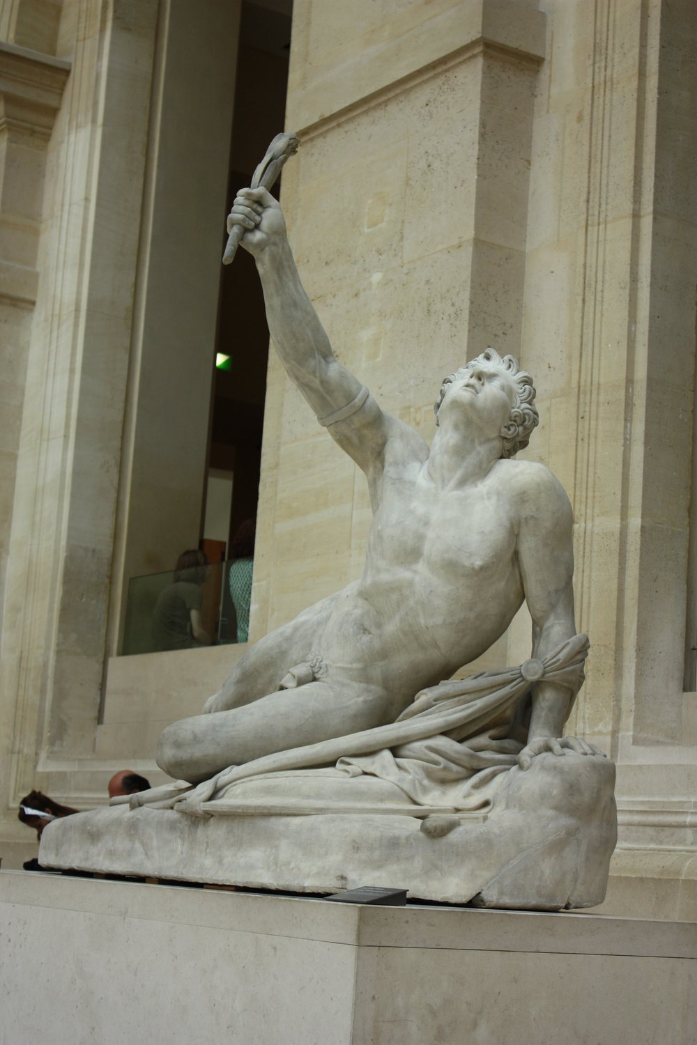 Marble statue of a dying young runner raising a palm branch
