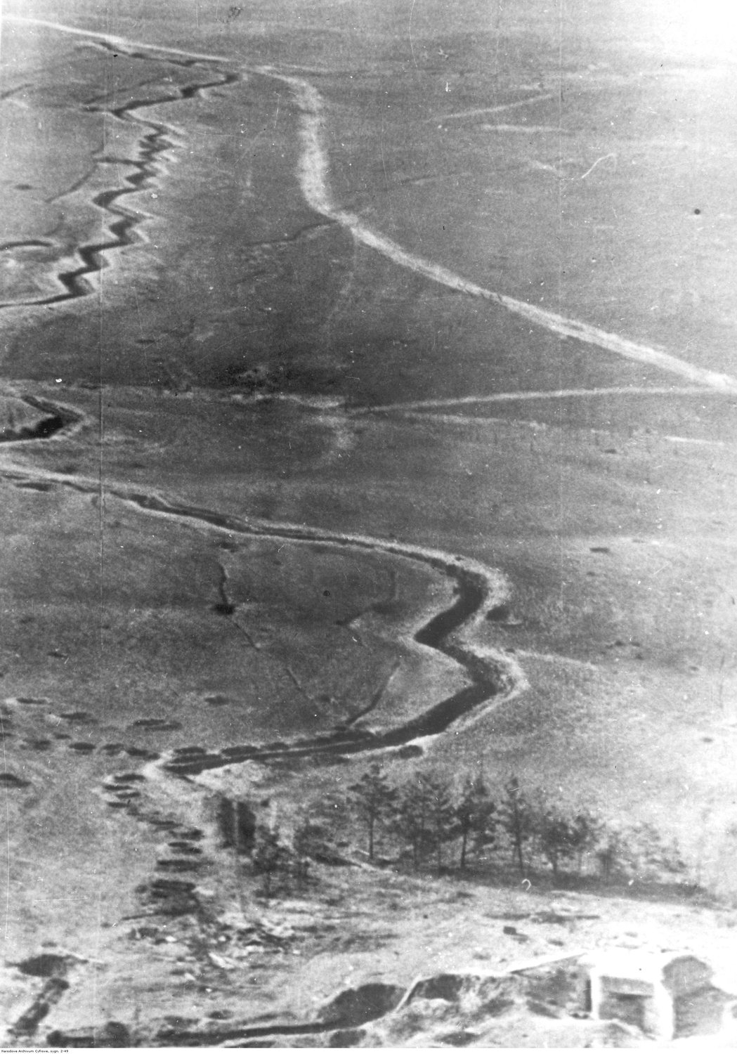 Black and white aerial photograph of zigzag trenches across open fields
