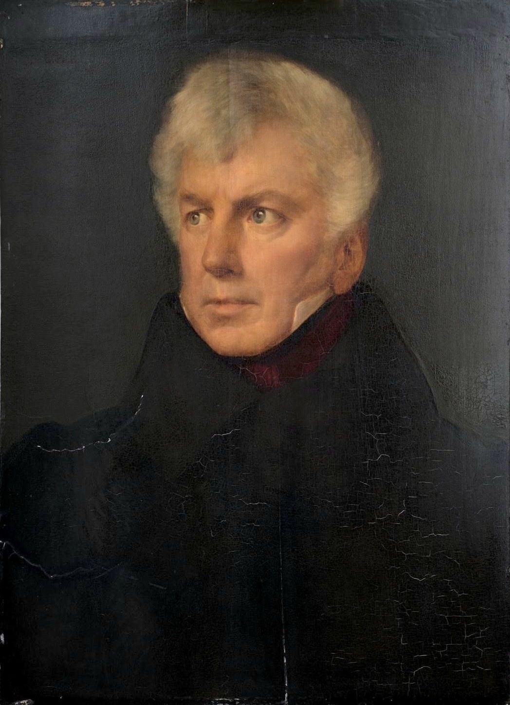 Portret siwowłosego mężczyzny w ciemnym płaszczu na ciemnym tle