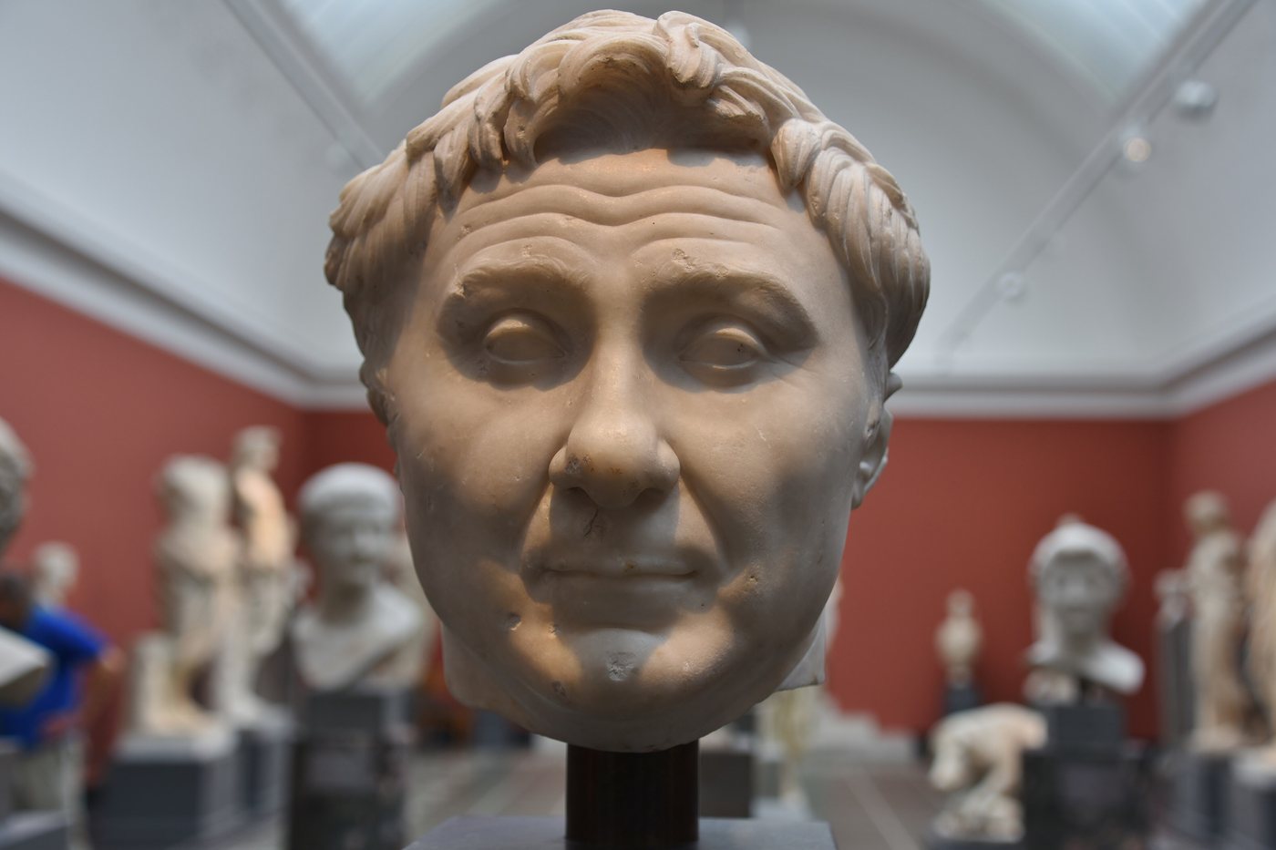 Marble head of a heavy faced Roman man with a raised quiff of hair