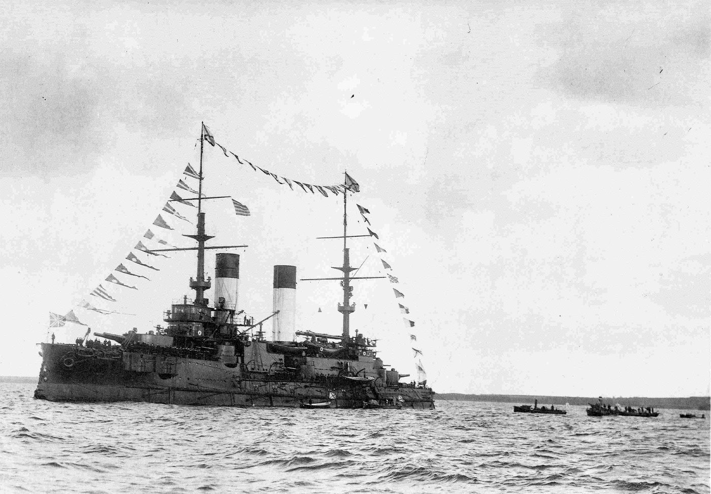 Black and white photograph of a Russian battleship with two funnels and lines of signal flags