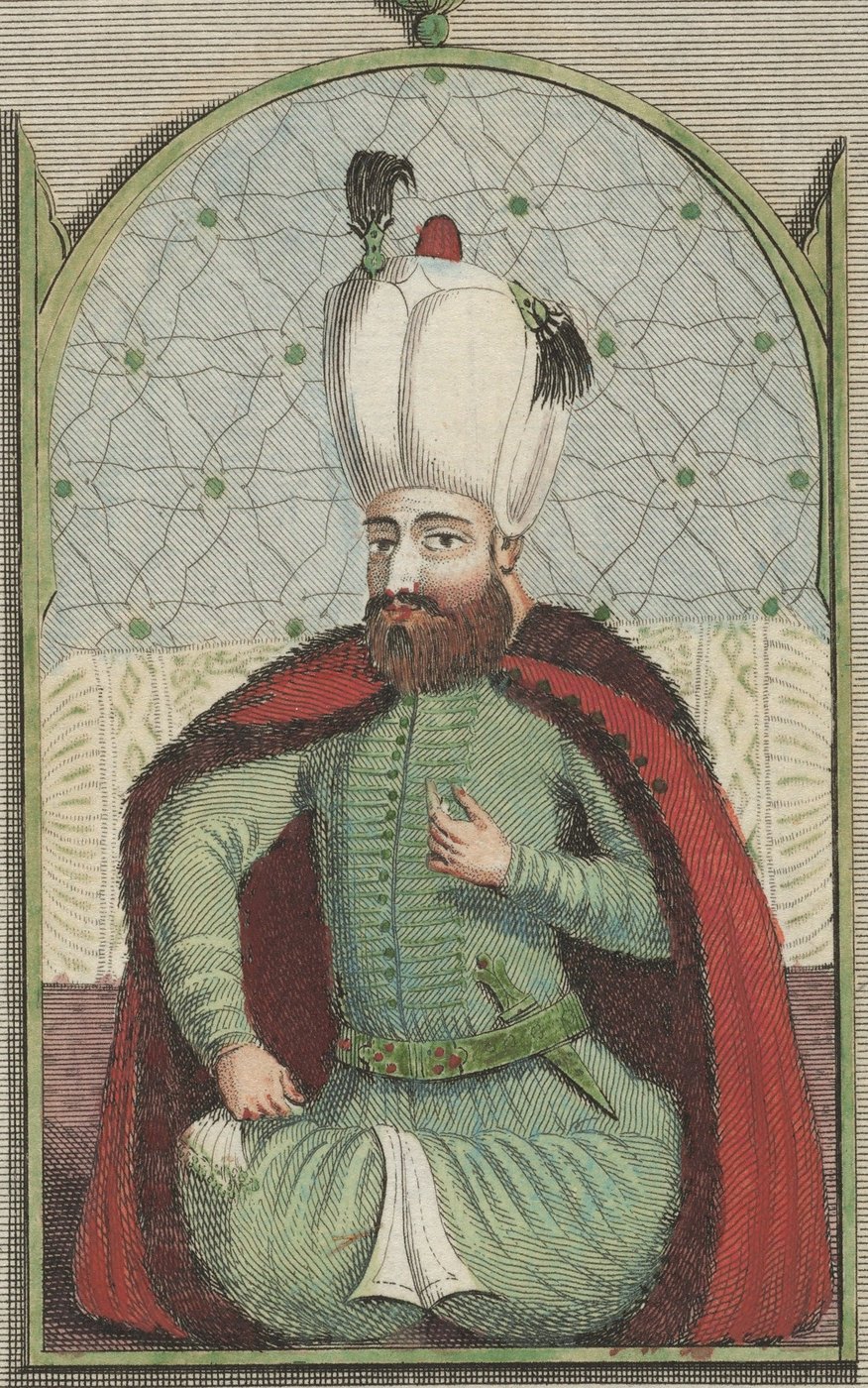 Hand-colored engraving of a bearded sultan in a tall white turban, a green robe and a red fur-lined cloak, seated cross-legged under a decorated arch