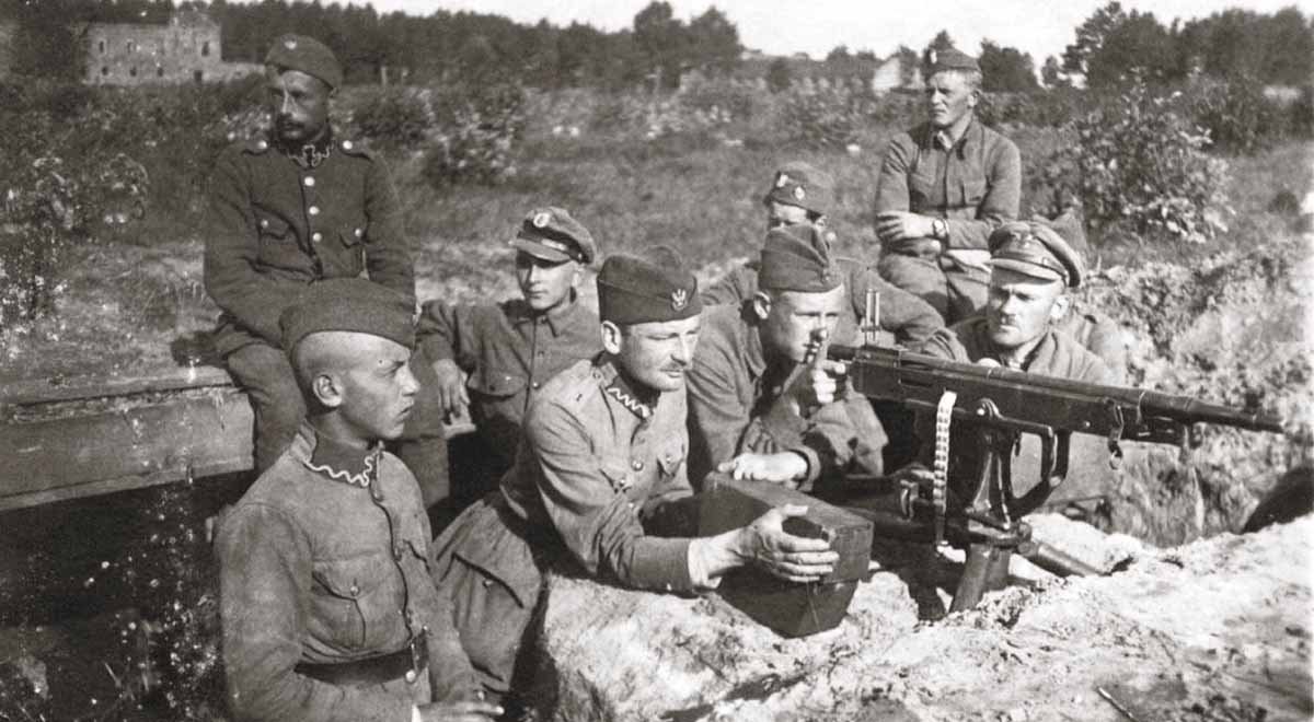 Black and white photograph of Polish soldiers in caps manning a machine gun in a trench