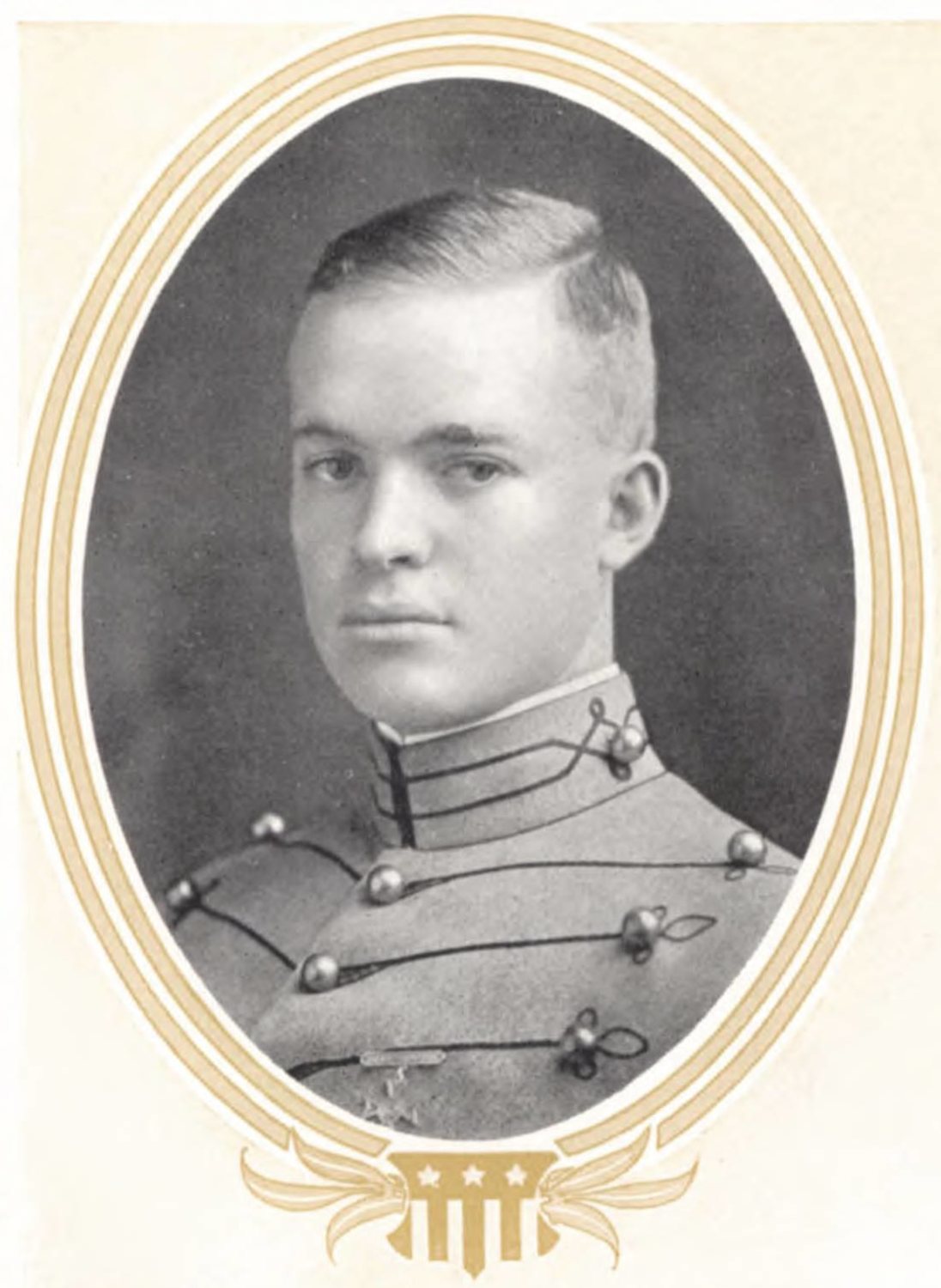 Oval black and white yearbook portrait of a young cadet in a high-collared grey uniform