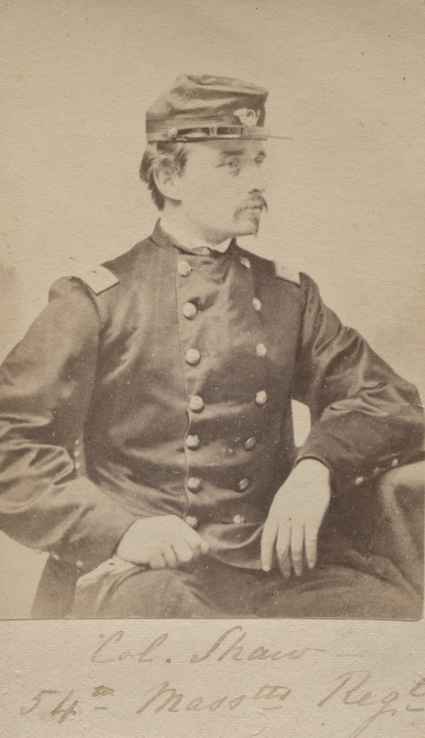 Old photograph of a young Union officer in uniform and kepi seated beside a table
