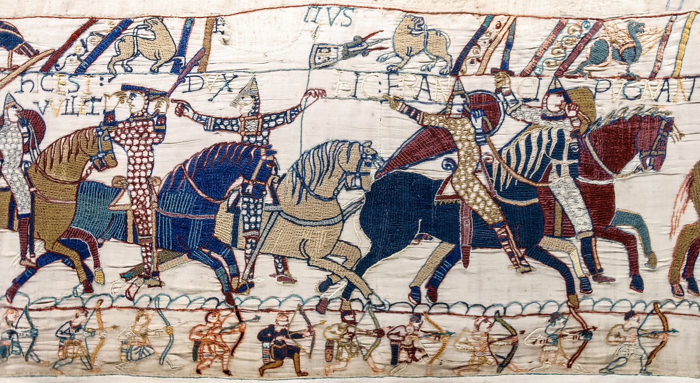Embroidered scene of Norman knights on horseback with archers in the lower border