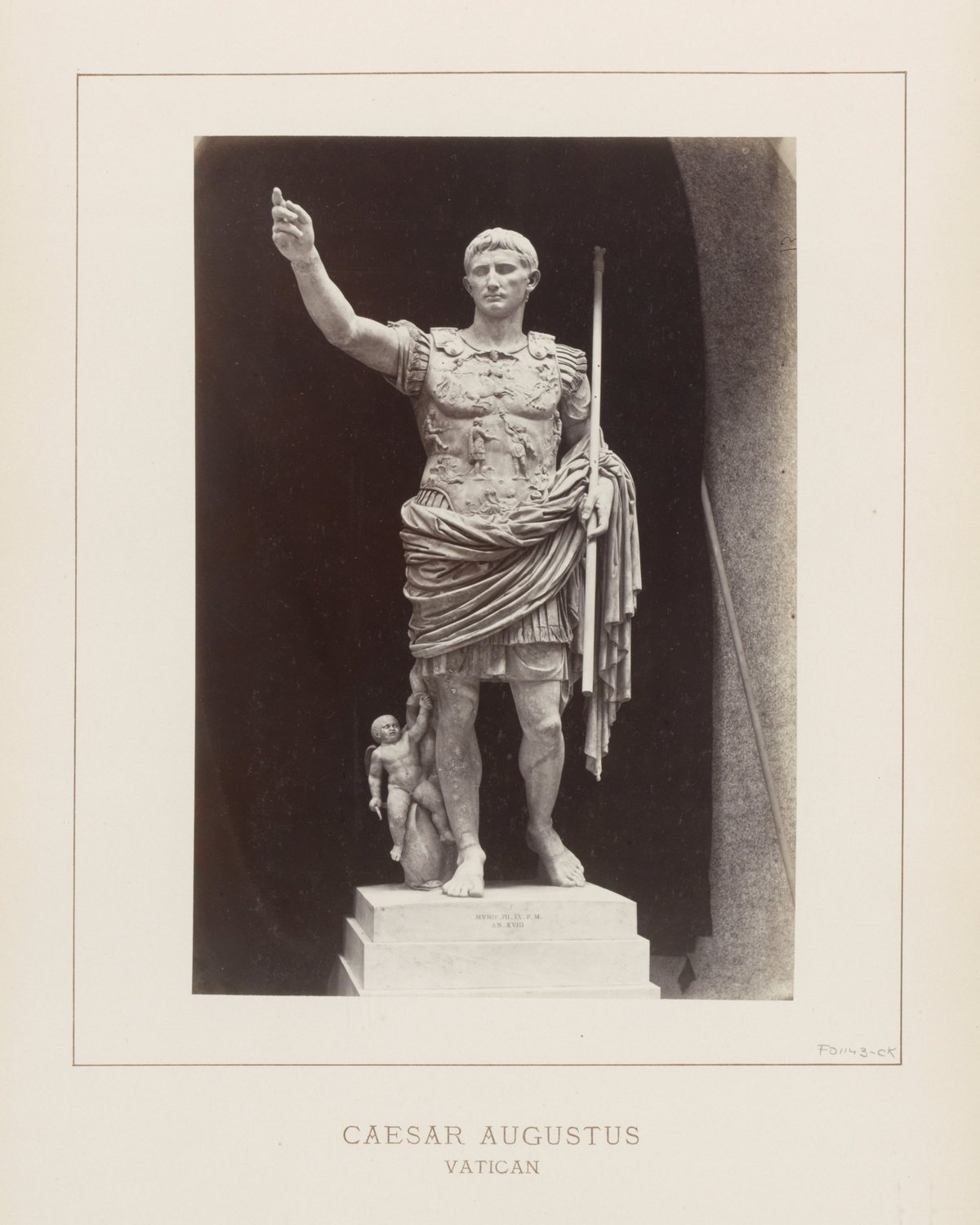 Old photograph of a marble statue of Augustus in armour raising his right arm