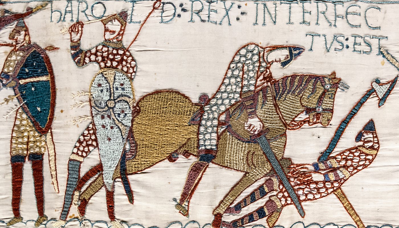 Embroidered scene of Norman horsemen cutting down English warriors