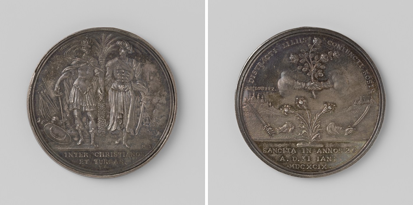 Both faces of a silver medal: on one, a crowned emperor and a turbaned sultan shake hands beside a palm tree above the words 'Inter Christianos et Turcas'; on the other, two clasped hands hold a rose bush over a town marked 'Carlowitz' with the inscription 'Sancita in annos 25'.