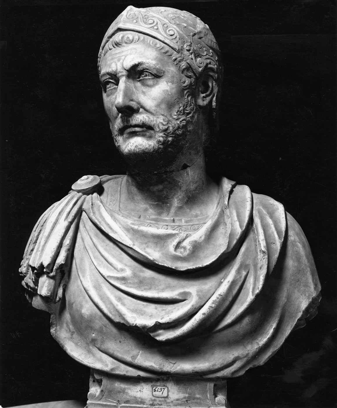 Black and white photograph of a marble bust of a bearded man in a cuirass and cloak