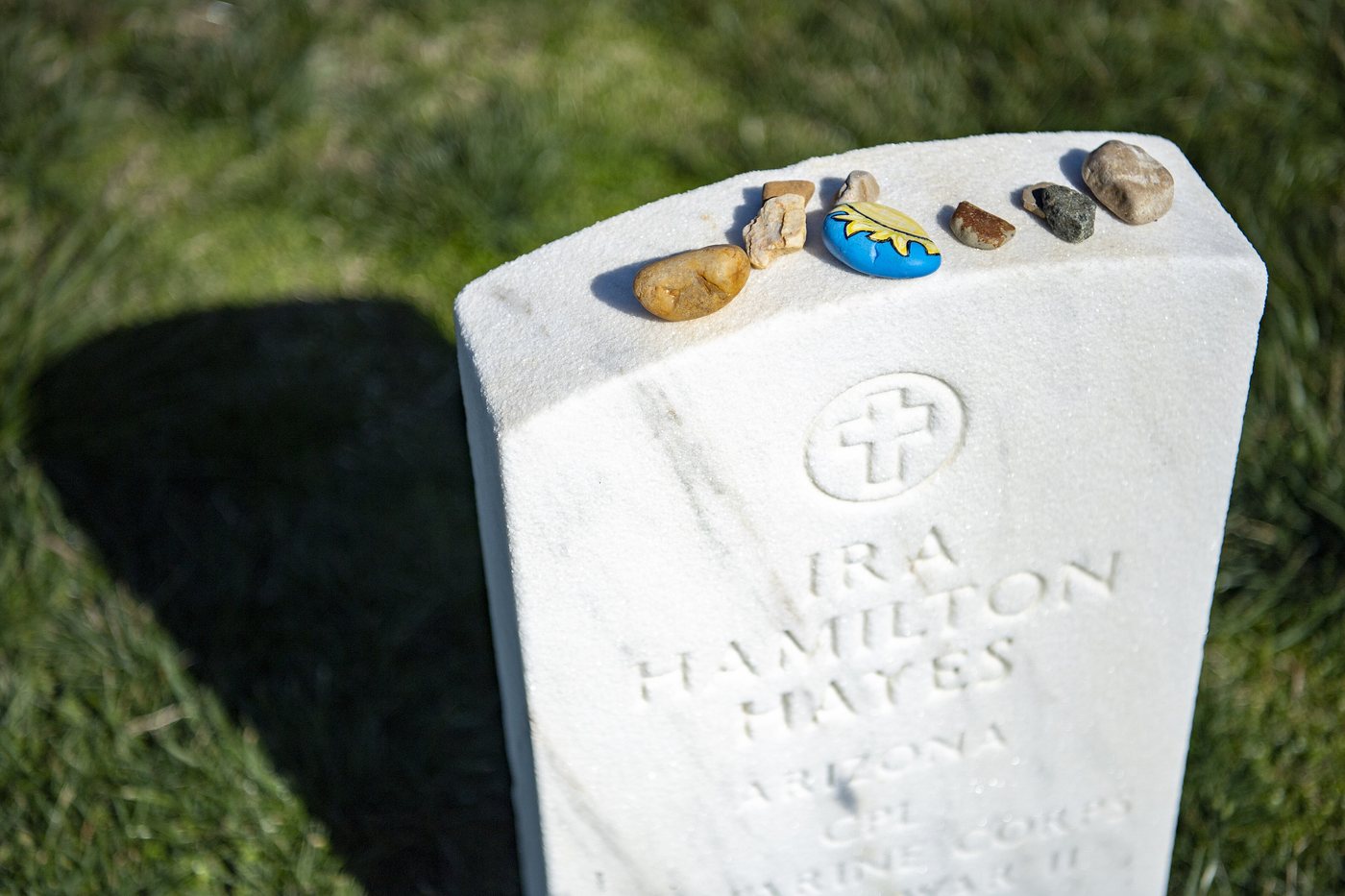 White headstone of Ira Hamilton Hayes with small stones placed on top