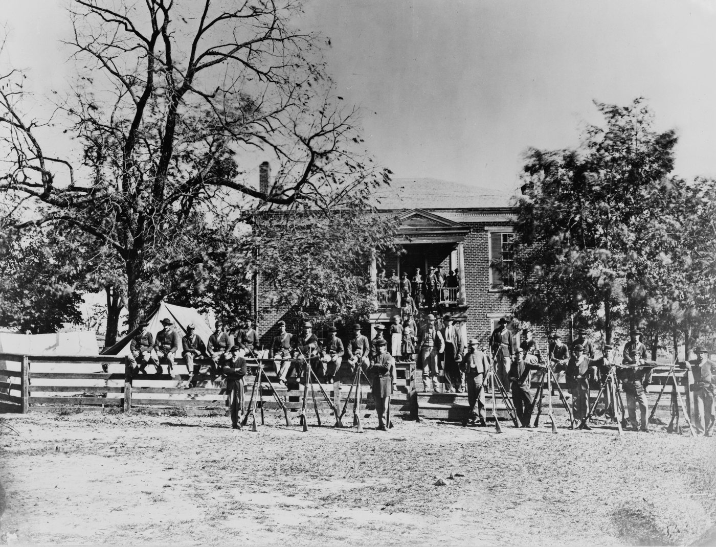 Black and white photograph of Union soldiers posing in front of a brick courthouse