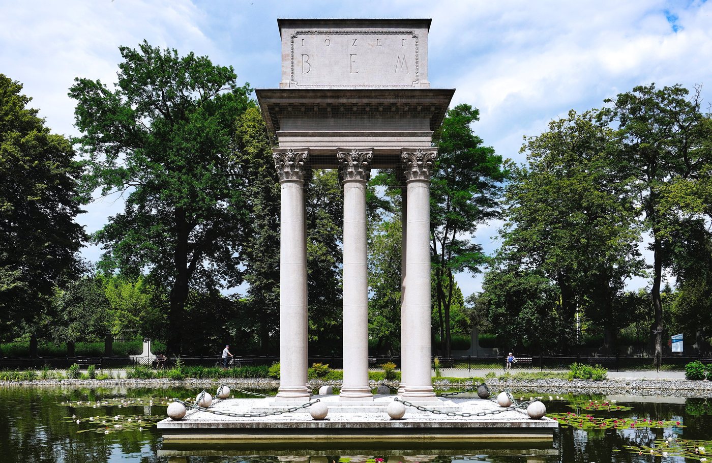Classical columned mausoleum on a pond surrounded by trees