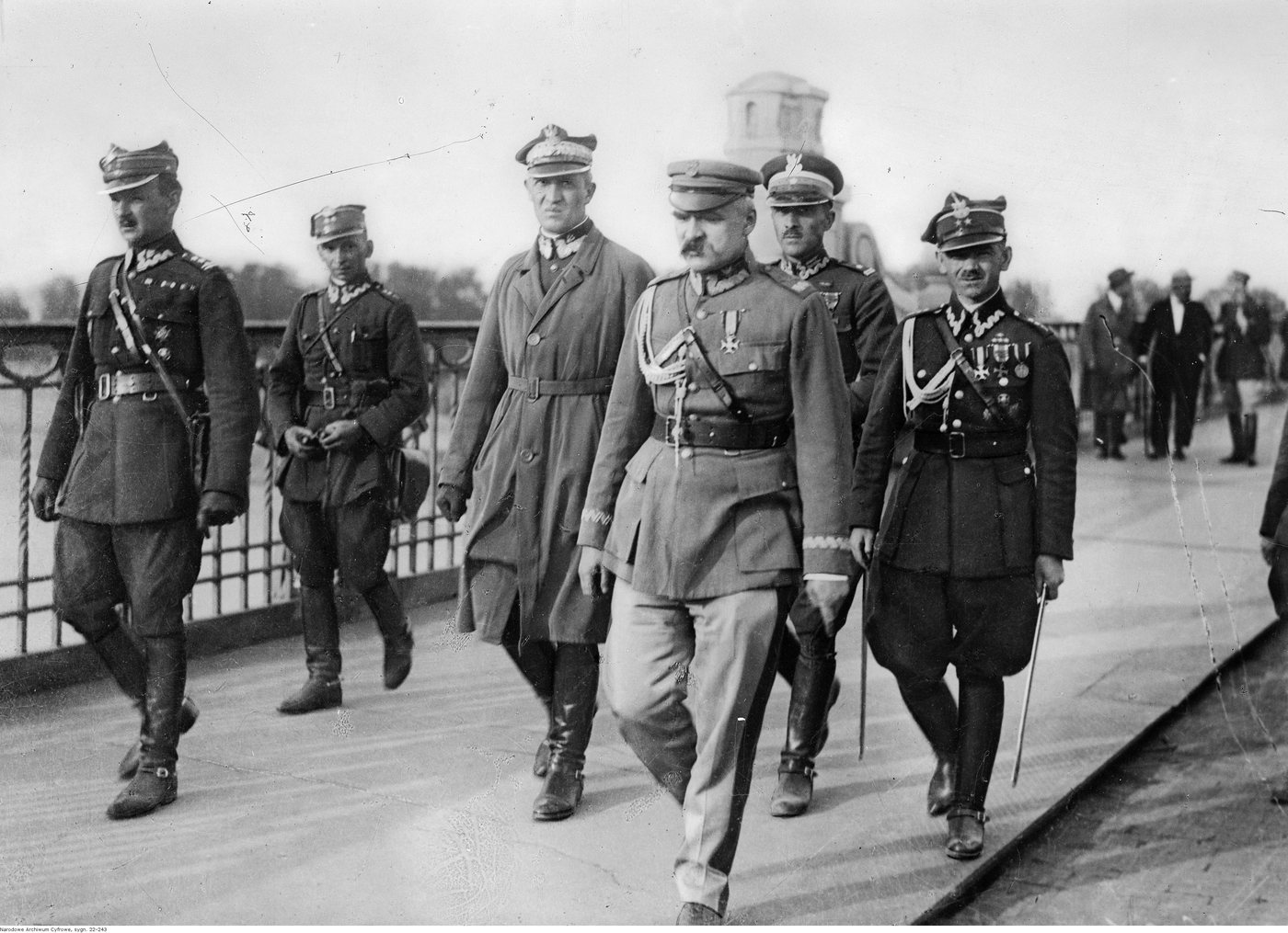 Piłsudski and a group of officers in greatcoats standing on a bridge, 1926