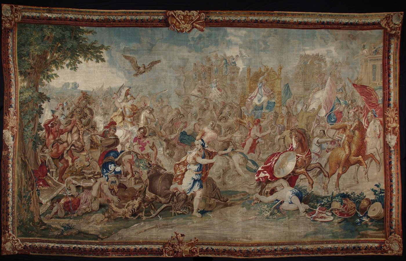 Tapestry of a crowded ancient battle with Alexander on horseback and Darius in a golden chariot in the background