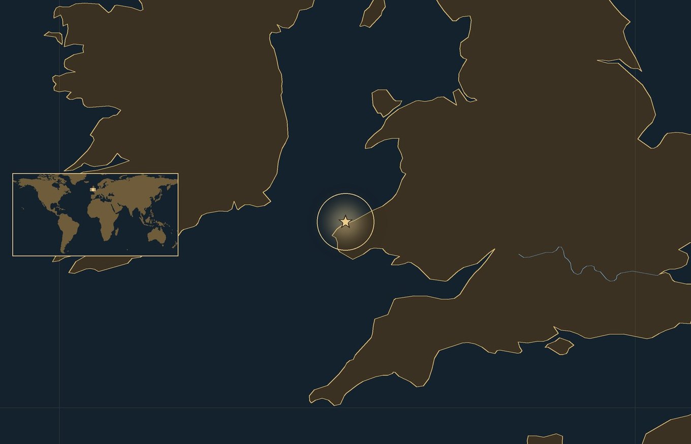 Ciemna mapa lokalizacyjna ze złotą gwiazdką w świecącym kółku, która wskazuje przybliżone miejsce bitwy: Bitwa pod Fishguard, z wybrzeżami, rzekami i jeziorami regionu oraz małą wkładką z mapą świata, na której zaznaczono ten obszar