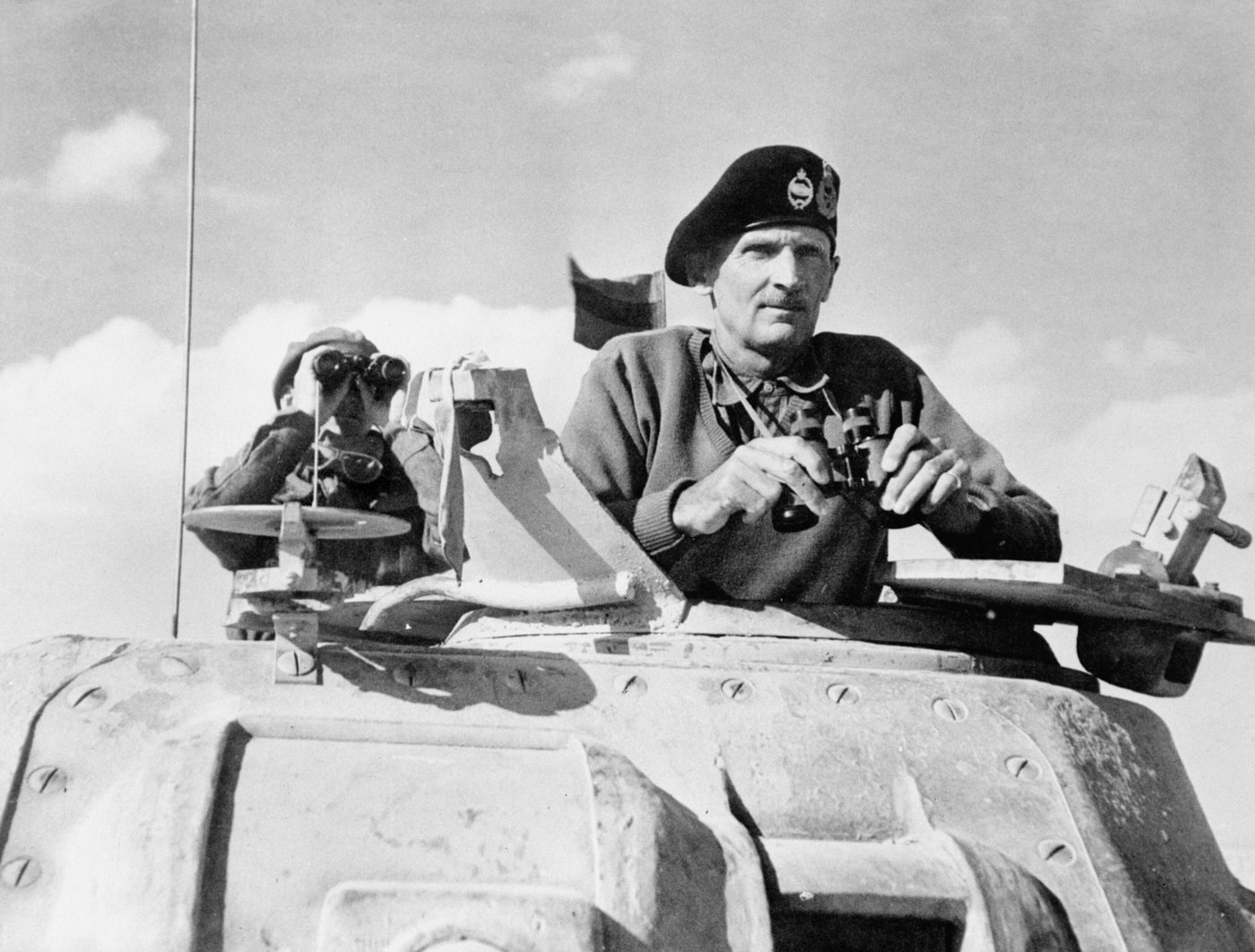 Montgomery w berecie wyglądający z wieży czołgu na pustyni