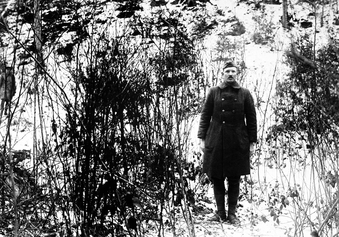 Alvin York w mundurze na zalesionym zboczu wskazuje coś po drugiej stronie doliny