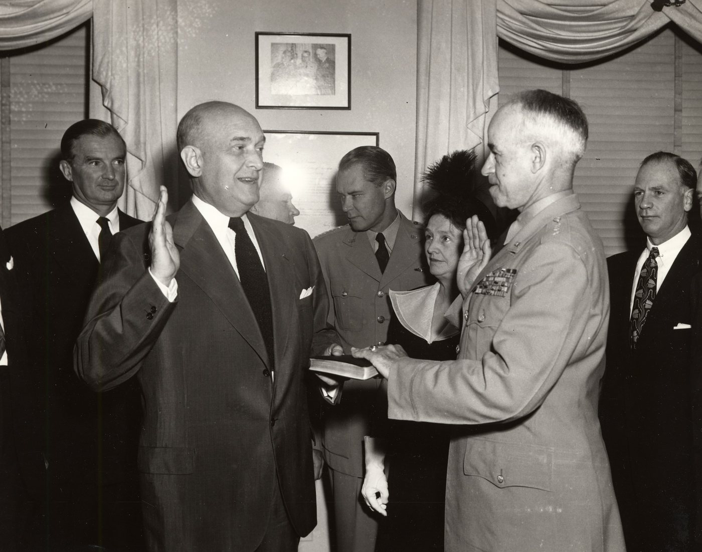 Black-and-white photo of a swearing-in ceremony with a civilian official and General Bradley in uniform