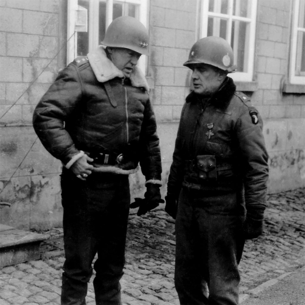 Two American generals in steel helmets and winter jackets talking in a cobbled street