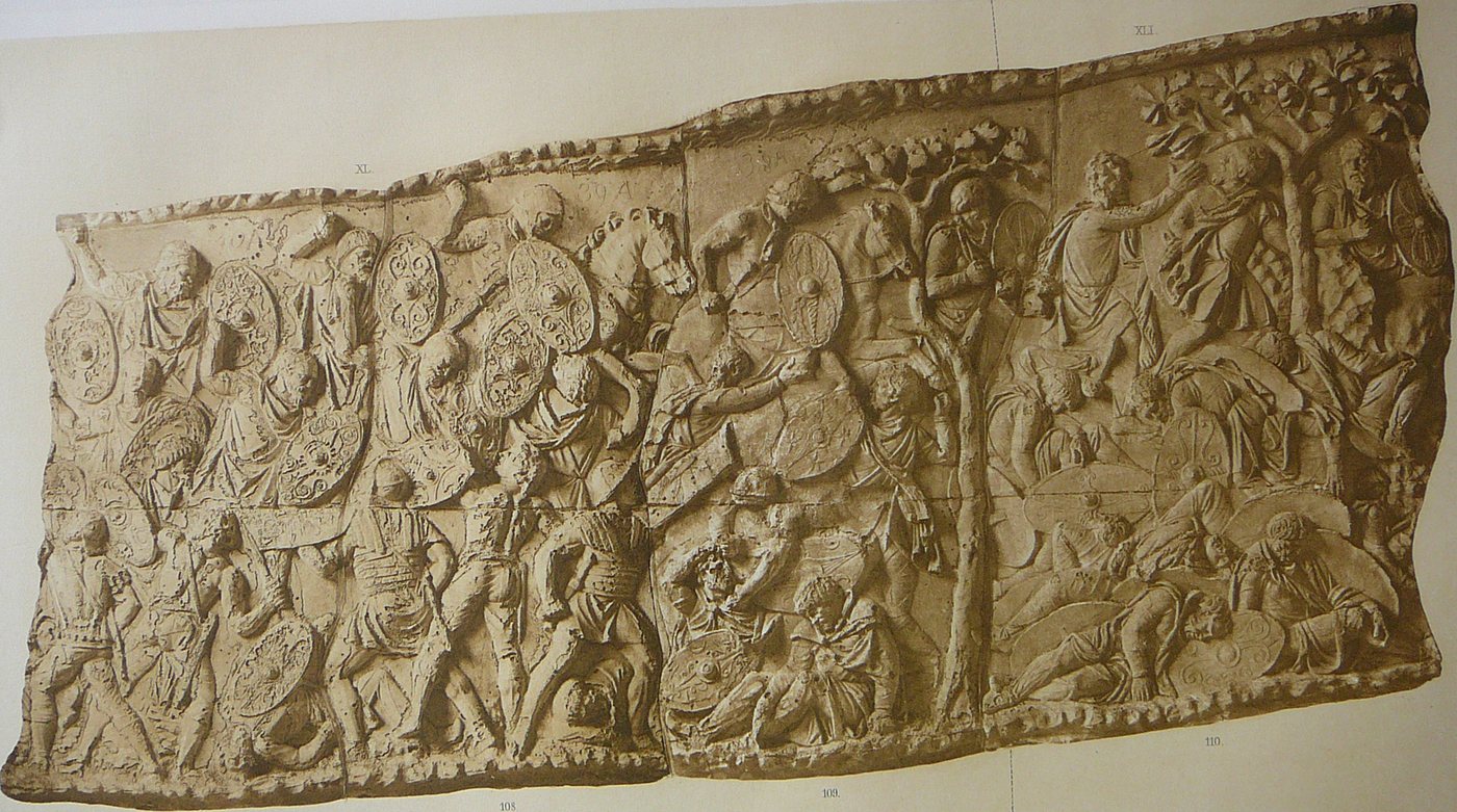 Photograph of a long stone relief crowded with Roman soldiers fighting Dacian warriors among trees