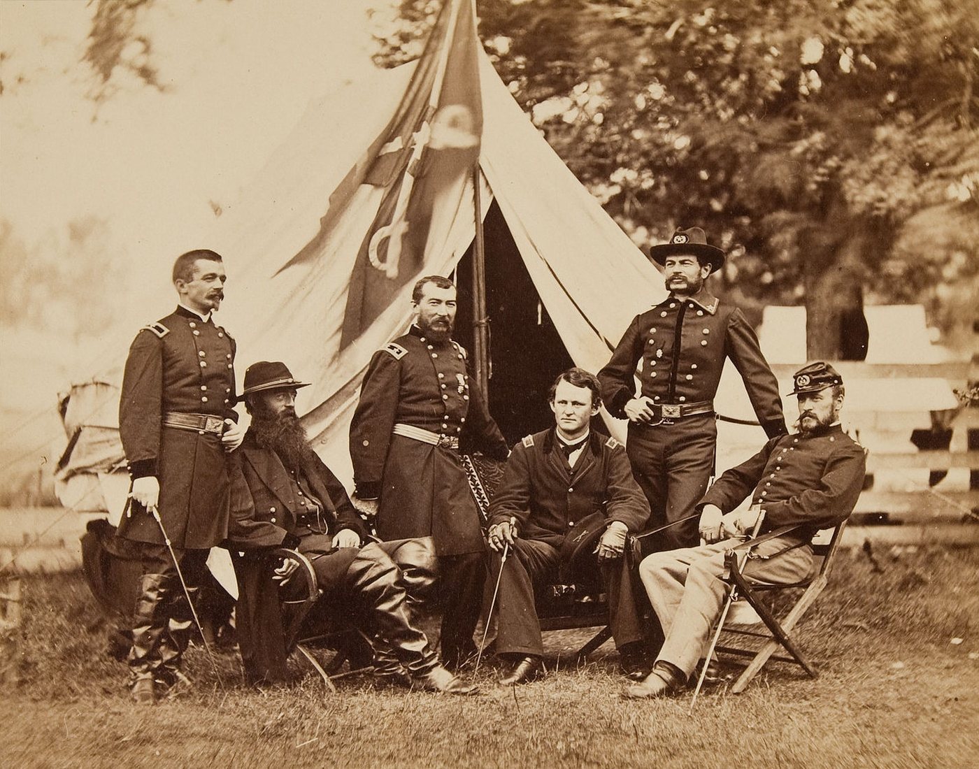 Six Union officers sitting and standing in front of a tent in a field, 1864