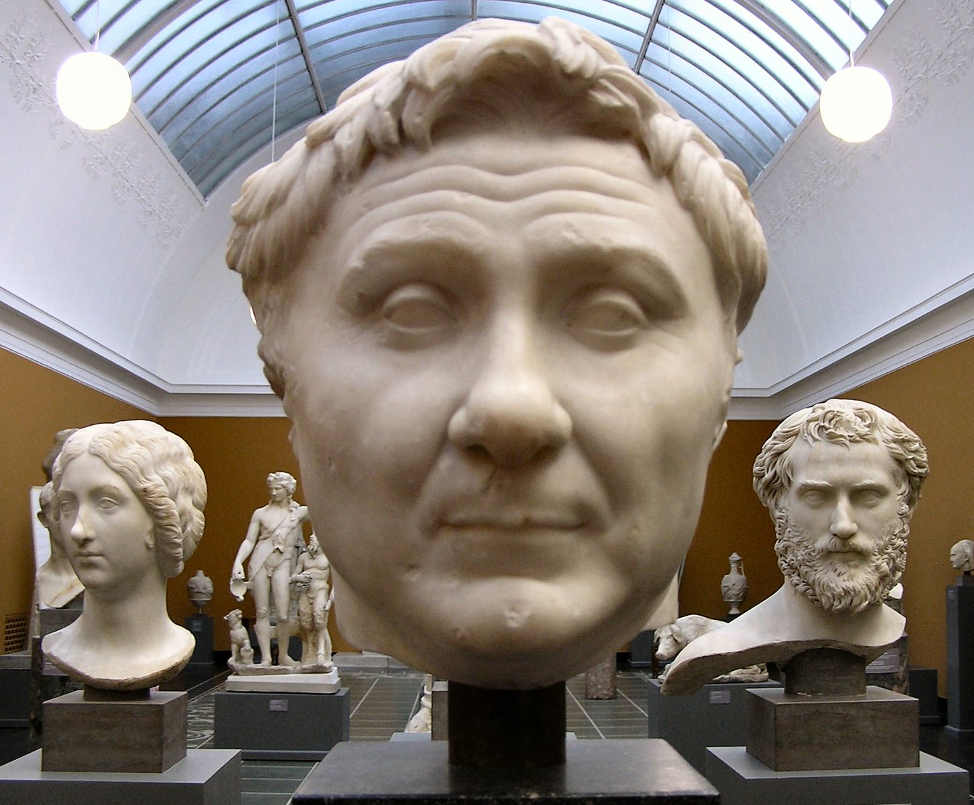 Marble head of Pompey with a broad face and tousled hair in a museum gallery