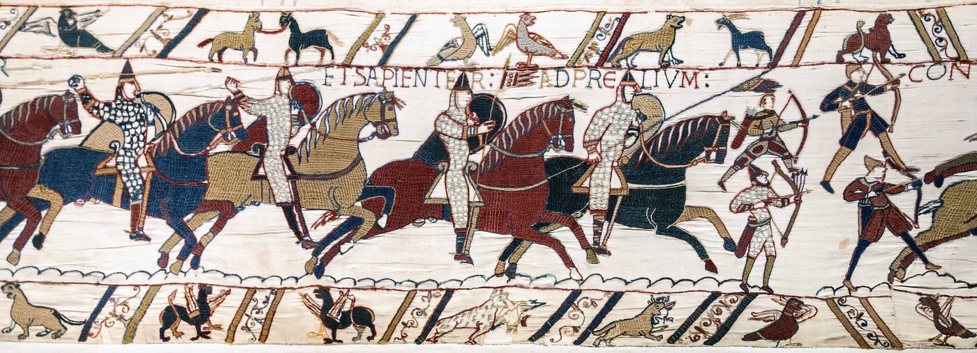 Embroidered frieze of mounted knights with lances and shields charging, with archers along the lower border