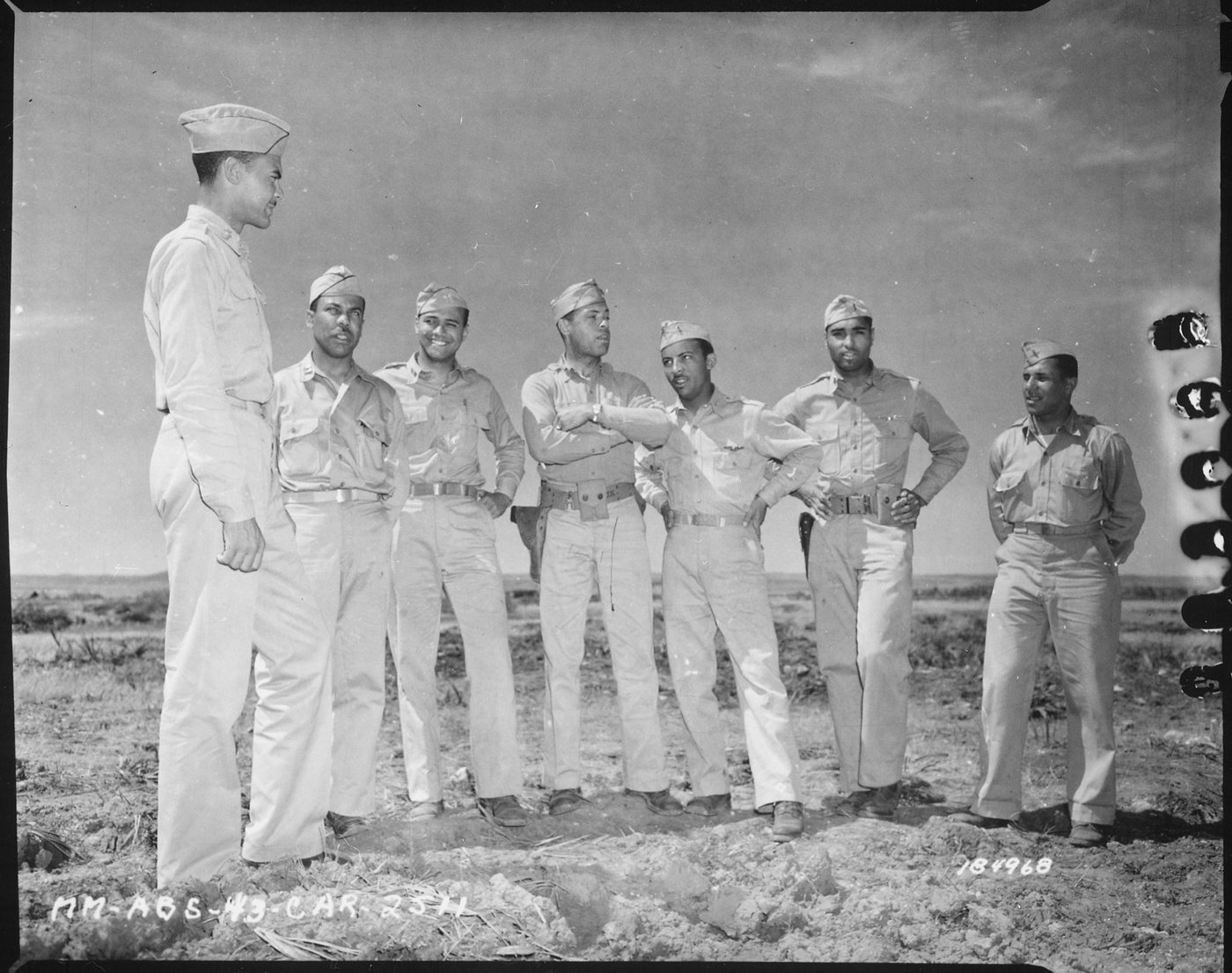 Black and white photograph of seven Black officers in uniform standing in a row outdoors